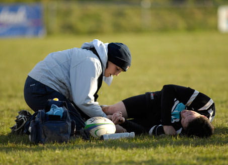 Image of doctor treating rugby player on field. Credit: Alamy 